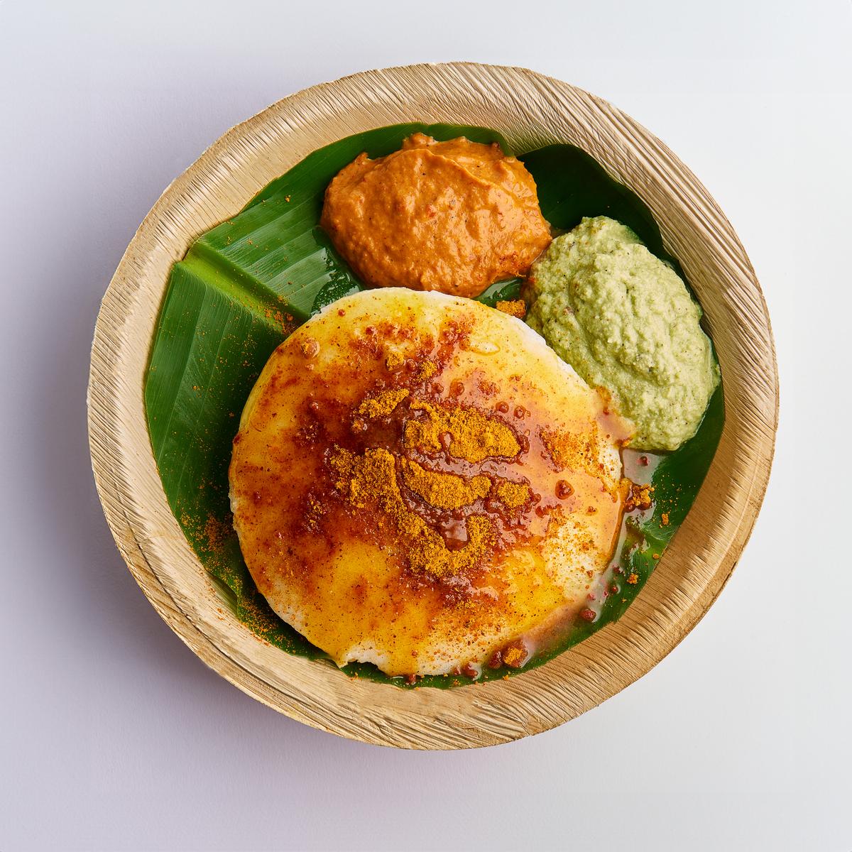 Podi thatte idli served with red and coconut chutneys